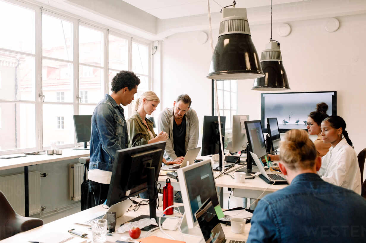 Creative business people working on computers in open plan office